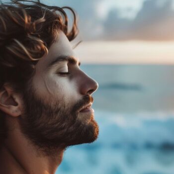 Man relaxing by the sea at sunset, enjoying the peaceful atmosphere.